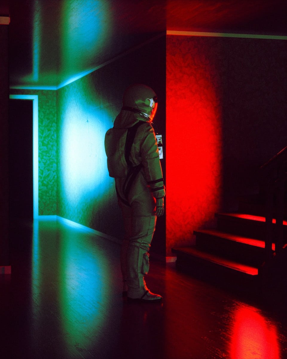 a person in a dark room with red and green lights